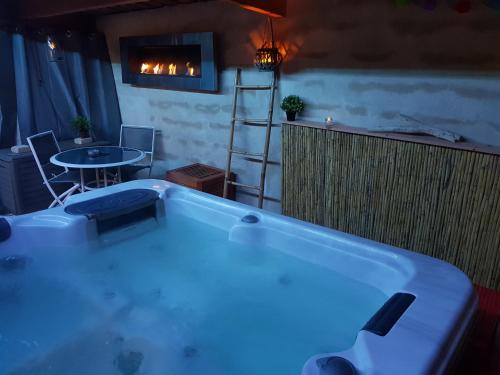 une grande baignoire dans une pièce avec une table dans l'établissement Villa Cottreau, à Marseille