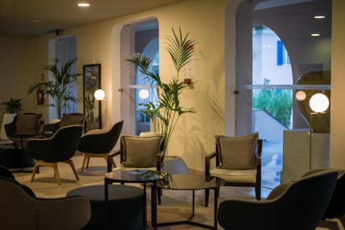 a living room filled with furniture and a large window at Azoris Faial Garden – Resort Hotel in Horta