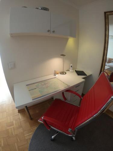 a red chair sitting in front of a desk at Haus - Bonsai Bonsai Apartments I in Bad Pyrmont