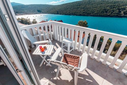 balcón con sillas, mesa y vistas al agua en Sea Oasis Apartments - Milosevic, en Kotor