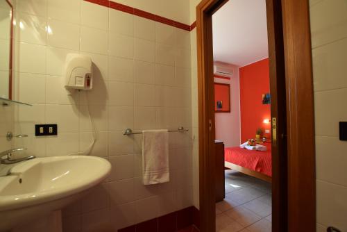 a bathroom with a sink and a bathroom with a bedroom at Hotel Iride by Marino Tourist in San Vito lo Capo