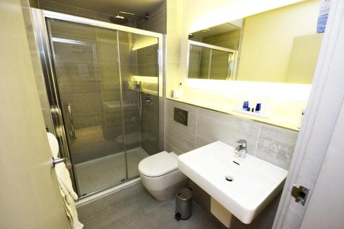 a bathroom with a shower and a toilet and a sink at Glynhill Hotel & Spa near Glasgow Airport in Paisley