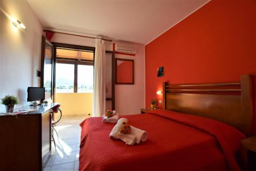a red bedroom with two stuffed animals on a bed at Hotel Iride by Marino Tourist in San Vito lo Capo