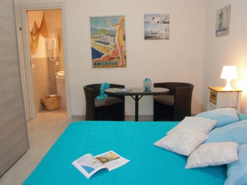 um quarto de hotel com uma cama azul e uma mesa em Le Onde em Levanto
