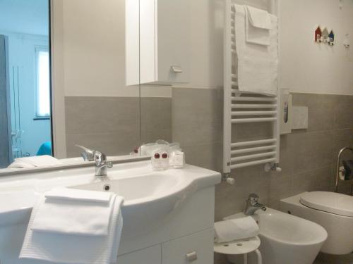 a bathroom with a sink and a toilet and a mirror at Le Onde in Levanto