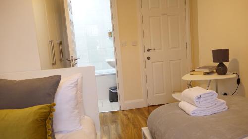 Zimmer mit Sofa und Tisch mit Lampe in der Unterkunft Heathrow Ensuite Rooms in Stanwell