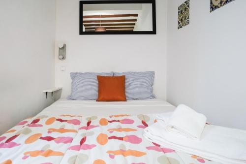 リスボンにあるSalvador Apartmentのベッドルーム1室(オレンジ色の枕付きのベッド1台付)