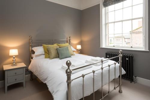 a bedroom with a bed and a window at Fossgate Bridge Apartments York in York