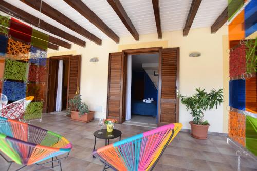 a patio with colorful chairs and a table at Hotel Iride by Marino Tourist in San Vito lo Capo