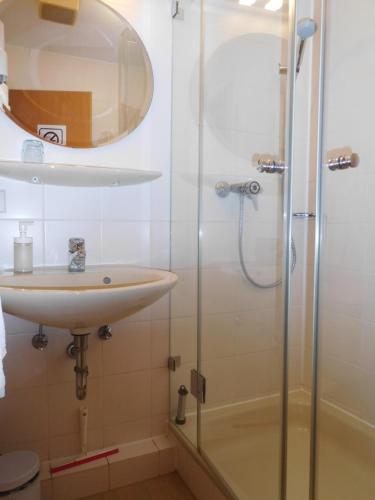 a bathroom with a sink and a shower at Arkadia Hotel in Burgwedel