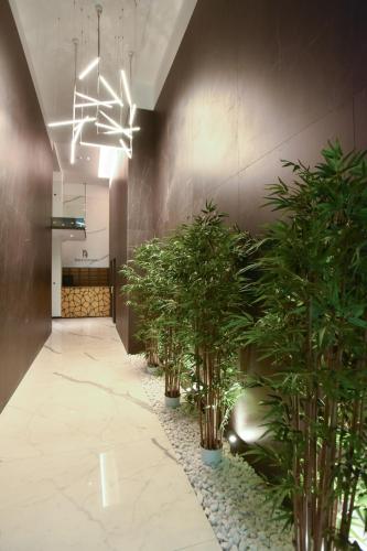 a hallway with potted plants and a chandelier at Royal Montesun Apartments in Budva