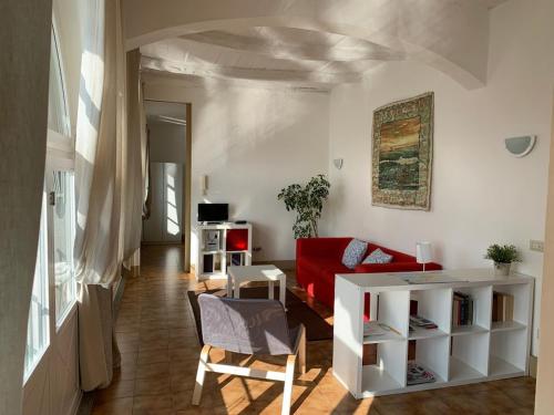 een woonkamer met een rode bank en een tafel bij -Ortaflats- Appartamento Gli Archi in Orta San Giulio