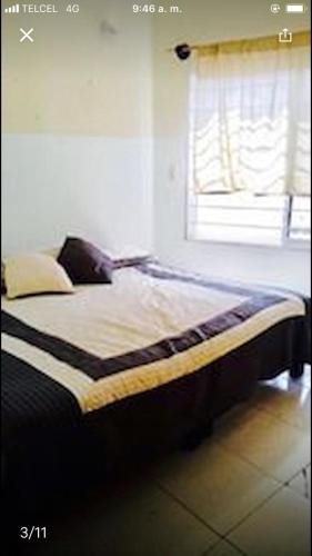uma cama num quarto com uma janela em casa cómoda y céntrica em Tuxtla Gutiérrez