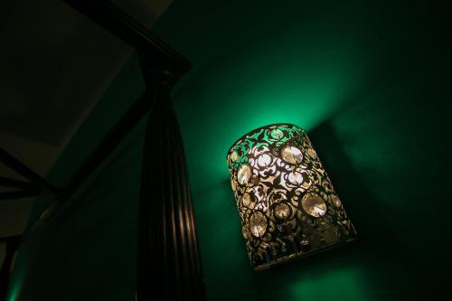 a lamp with a green light on a green wall at B&B La Corte in Chioggia
