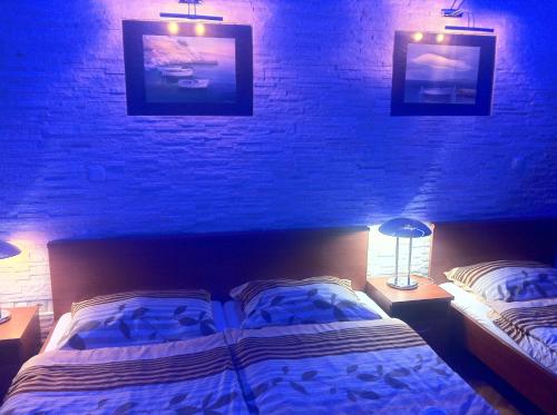 a bedroom with two beds and a brick wall at Apartments and bungalows vila Dalibor in Nin