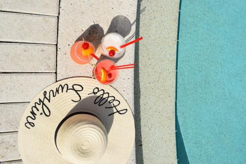 a hat and glasses next to a swimming pool at Cove Inn on Naples Bay in Naples