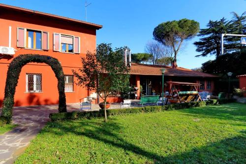 an orange house with a green yard in front of it at Antico Platano in Rome