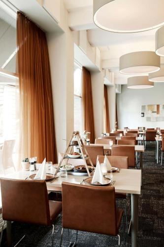 a dining room with long tables and chairs at Comwell Rebild Bakker in Skorping