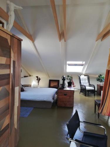 a bedroom with a bed and a chair in a room at Naiadi Loft Apartment in Nerezine