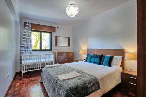 a bedroom with a large bed with blue pillows at Garden Cristo Rei in Lisbon