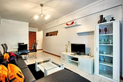a living room with a couch and a tv at Garden Cristo Rei in Lisbon