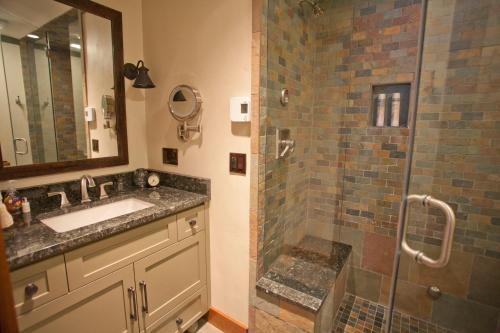 uma casa de banho com um lavatório e um chuveiro em Penthouse By The Gondola em Telluride