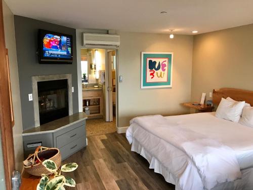 a bedroom with a bed and a tv on the wall at Cambria Shores Inn in Cambria