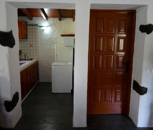 CASA RURAL LOS FRONTONES في سان سيباستيان دي لا غوميرا: مطبخ بباب احمر وثلاجة