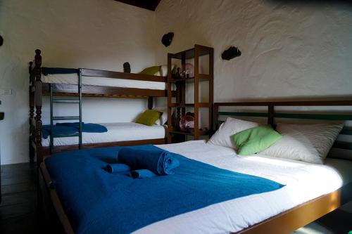 una camera con 2 letti a castello con lenzuola blu di CASA RURAL LOS FRONTONES a San Sebastián de la Gomera