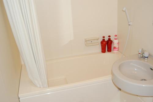 a bathroom with a shower and a toilet and a sink at Minshuku Shizu in Onna