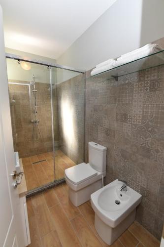 Un baño con inodoro, ducha y lavabo. en SANTO Hotel, en Shkodër