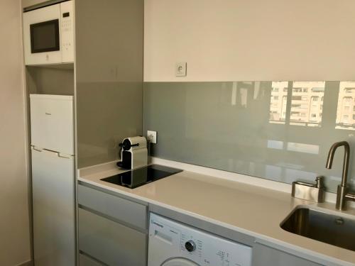 uma pequena cozinha com um lavatório e um frigorífico em Apartamento Sol y Mar em Torremolinos