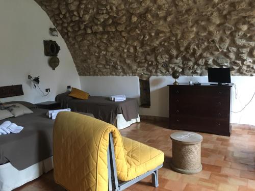 パリヌーロにあるL'Antica Torre Del Portoのベッド2台と黄色い椅子が備わる客室です。