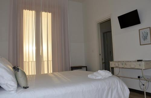 a white bedroom with a bed and a window at La Casa nel Borgo Antico in Melfi
