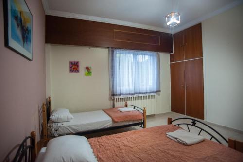 a room with two beds and a window at Retro Chic Apartment in Argostoli