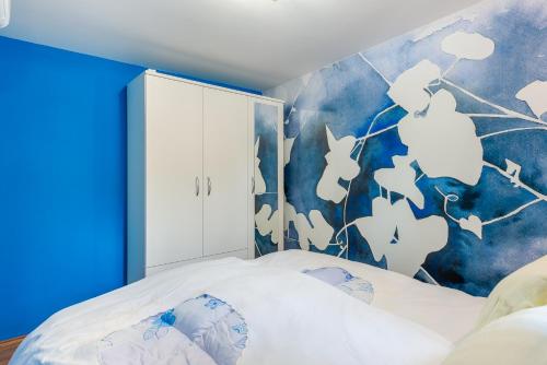 ein Schlafzimmer mit einem Bett mit einer blauen Wand in der Unterkunft Captain's Place in Dubrovnik