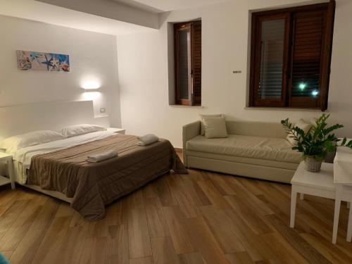 um quarto com uma cama e um sofá em Hotel Il Pirata em Cinisi