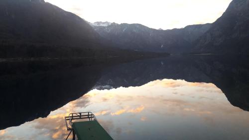 a view of a lake with a boat in the water at Snežak (Snowman) in Bohinj