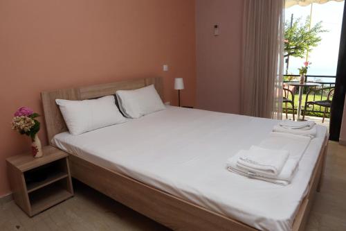 ルツァにあるSelini hotelのベッドルーム1室(白いシーツ付きのベッド1台、バルコニー付)