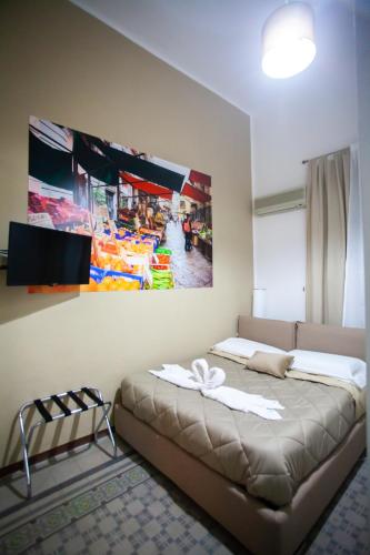 a bedroom with a bed and a painting on the wall at ALBA DEL CAPO in Palermo