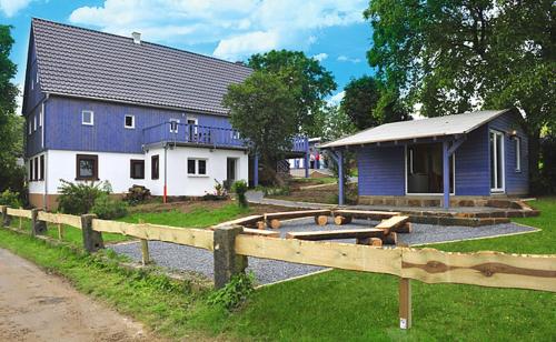 a blue and white building with a house at Bergoase Hütte und Hostel Sauna Kamin Lagerfeuer in Mittelndorf