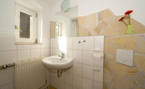 a white bathroom with a sink and a window at Bergoase Hütte und Hostel Sauna Kamin Lagerfeuer in Mittelndorf