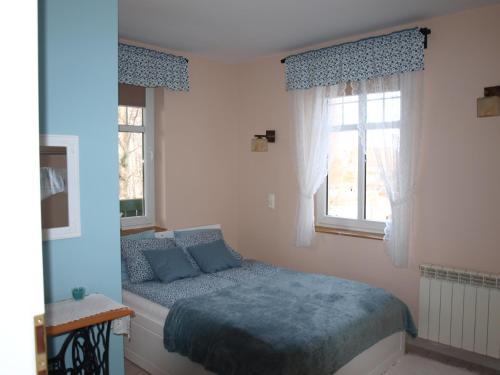 una camera con un letto e due finestre di Dom pod Kogutem a Pasym