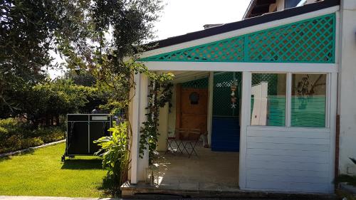 a white house with a blue roof and a door at Le Radici Casa Vacanze in Copertino
