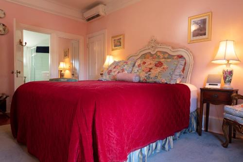 a bedroom with a large bed with a red blanket at The Bissell House Bed & Breakfast in Pasadena