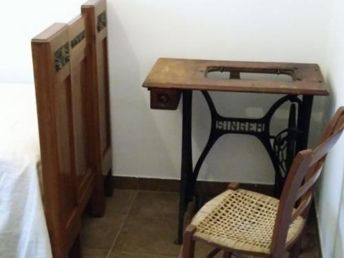a wooden table with a chair next to a desk at Zù Mariu B&B in Piazza Armerina