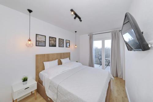 - une chambre blanche avec un lit et une télévision dans l'établissement Villa Divinus, à Polača