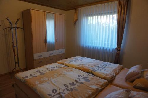 Bruchweiler-BärenbachにあるFerienwohnung Jüngstbergblickのベッド2台とドレッサーと窓のある寝室