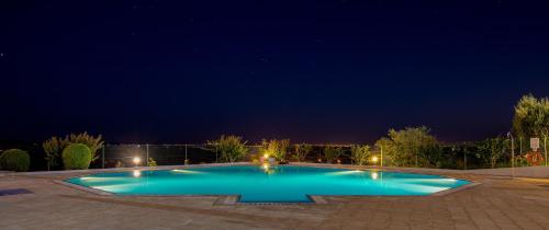 a large blue swimming pool at night at Santarem Hotel in Santarém