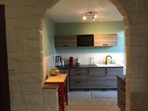an archway in a kitchen with a sink and a counter at Pied à terre in Blainville-sur-lʼEau